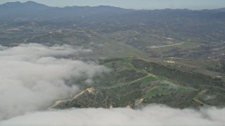 AX0016_036 - 5K aerial stock footage of clouds by a military base training camp, Camp Pendleton, California