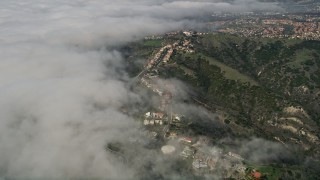 AX0016_039 - 5K aerial stock footage approach upscale hillside homes by low clouds, San Clemente, California
