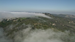 AX0016_054E - 5K aerial stock footage follow the edge of the clouds to approach hillside homes, Laguna Niguel, California