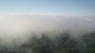 AX0016_065 - 5K aerial stock footage of flying by the edge of a cloud bank, Laguna Beach, California