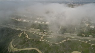 AX0016_072 - 5K aerial stock footage approach residential roads near suburban homes and beneath clouds; Newport Beach, California
