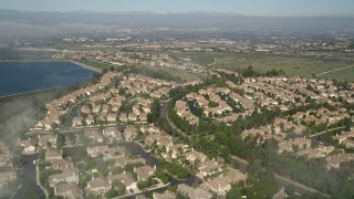 AX0016_073 - 5K aerial stock footage fly over residential neighborhood beside the San Joaquin Reservoir, Newport Beach, California