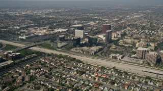 AX0016_085E - 5K stock footage aerial video fly over homes to approach office buildings on the other side of Interstate 405, Costa Mesa, California