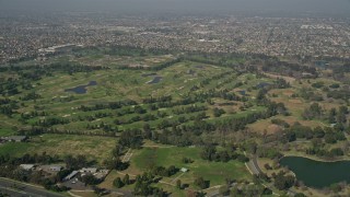 AX0016_092E - 5K aerial stock footage of approaching Mile Square Regional Park and golf course, Fountain Valley, California