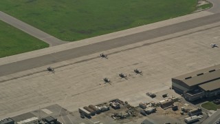 AX0016_099 - 5K stock footage aerial video flyby parked military helicopters at Los Alamitos Army Airfield, California
