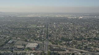 AX0016_105 - 5K aerial stock footage tilt from East Warlow Road through neighborhoods to reveal and approach Long Beach Airport, California