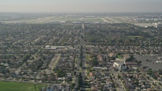 AX0016_106 - 5K stock footage aerial video tilt up East Warlow Road to reveal and approach neighborhoods and Long Beach Airport, California