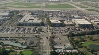 AX0016_109E - 5K stock footage aerial video tilt from East Warlow Road to reveal and approach parking garage at Long Beach Airport, California