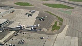AX0016_112 - 5K aerial stock footage of civilian jets parked near a hangar at Long Beach Airport, California