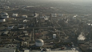 AX0017_005 - 5K stock footage aerial video of flying by an oil refinery and smoke stacks, Carson, California