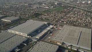 AX0017_007 - 5K aerial stock footage fly over warehouses toward a residential neighborhood, Carson, California
