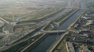 AX0017_010 - 5K stock footage aerial video fly over heavy interstate traffic along a river, Carson, California
