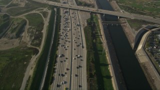 AX0017_024 - 5K stock footage aerial video of following heavy interstate traffic along the river, Carson, California