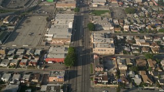 AX0017_036 - 5K stock footage aerial video of following a city street past apartment buildings, South Central Los Angeles