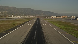 AX0017_113 - 5K aerial stock footage of lifting off from Bob Hope International Airport revealing a passenger jet, Burbank, California