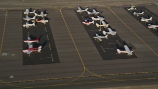 AX0017_119 - 5K aerial stock footage of airplanes on the tarmac at Whiteman Airport, Pacoima, California, sunset