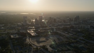 AX0018_010 - 5K aerial stock footage orbit Downtown Orlando with rising sun in the distance in Florida