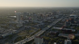 AX0018_011E - 5K aerial stock footage of Downtown Orlando and Interstate 4 at sunrise in Florida