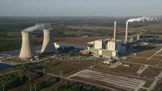 AX0018_028E - 5K aerial stock footage of Stanton Energy Center power plant in Orlando at sunrise in Florida