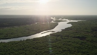 AX0018_040E - 5K aerial stock footage of a slow approach to St. Johns River near Orlando at sunrise, Florida