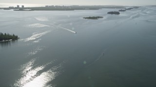 AX0018_093E - 5K aerial stock footage approach and track a fishing boat in the Indian River, Florida