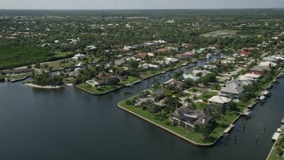 AX0019_011 - 5K aerial stock footage of waterfront homes on canals in Hobe Sound, Florida
