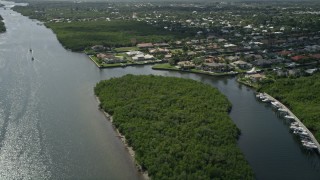 AX0019_013E - 5K aerial stock footage fly over Indian River and pan to approach waterfront homes in Hobe Sound, Florida