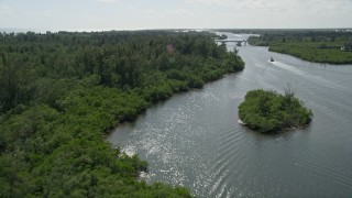 AX0019_015E - 5K aerial stock footage approach and fly over mangroves lining the Indian River near bridge in Hobe Sound, Florida