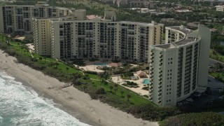 AX0019_037E - 5K aerial stock footage approach large beachfront condominium buildings in Jupiter, Florida