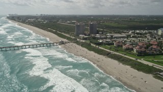 AX0019_043E - 5K aerial stock footage approach pier and beachgoers in Juno Beach, Florida