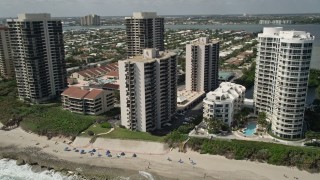 AX0019_047 - 5K aerial stock footage of beachfront condominium complexes by the ocean in Riviera Beach, Florida