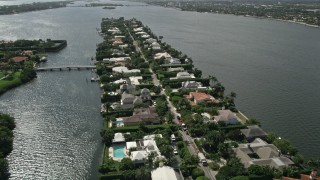 AX0019_063E - 5K aerial stock footage approach and fly over lakefront mansions in Palm Beach