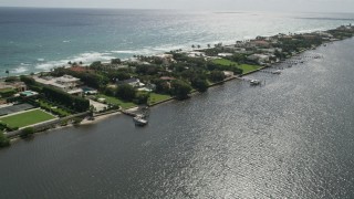 AX0019_069E - 5K aerial stock footage of passing waterfront mansions with docks on Lake Worth in Palm Beach, Florida