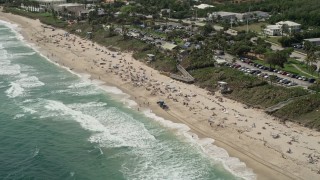 AX0019_085 - 5K aerial stock footage of approaching a beach with sunbathers in Boynton Beach, Florida