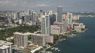 AX0020_019E - 5K aerial stock footage flyby bayfront condominium complexes to approach Downtown Miami hotel and skyscrapers, Florida