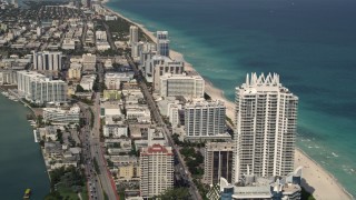 AX0020_061E - 5K aerial stock footage of beachfront condominium skyscraper, and wide view of hotels in Miami Beach, Florida