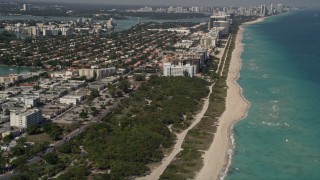 AX0020_065 - 5K aerial stock footage tilt from beachfront homes and park to reveal coastal hotels in Miami Beach and town of Surfside, Florida