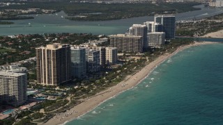 AX0020_069 - 5K aerial stock footage of a row of oceanfront hotels and condominiums by the beach in Bal Harbour, Florida