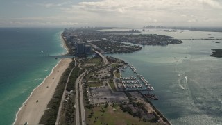 AX0020_089E - 5K aerial stock footage fly over coastal road by the beach and tilt to reveal more coast through Bal Harbour, Florida