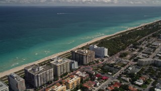 AX0020_096 - 5K aerial stock footage of oceanfront apartments and beach by a park in Surfside, Florida