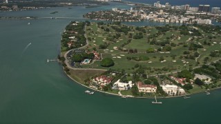 AX0020_100 - 5K aerial stock footage of waterfront mansions and golf course on the island of Indian Creek, Florida