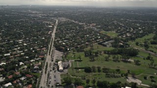 AX0020_102E - 5K aerial stock footage follow canal through waterfront suburbs and tilt from boulevard to reveal country club in Miami Shores, Florida