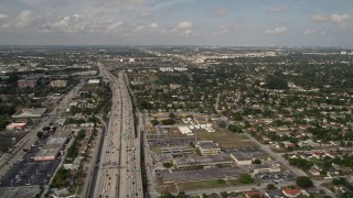 AX0021_001 - 5K aerial stock footage of freeway through suburbs in Golden Glades, Florida