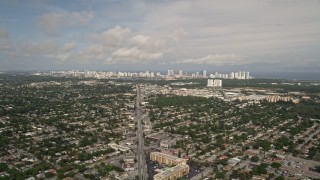 AX0021_002 - 5K aerial stock footage of suburban area with distant coastal skyscrapers in Sunny Isles Beach, Florida