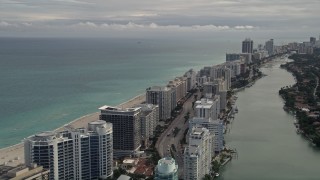 AX0021_024 - 5K aerial stock footage tilt from Indian Creek Drive to row of oceanfront condominiums in Miami Beach, Florida