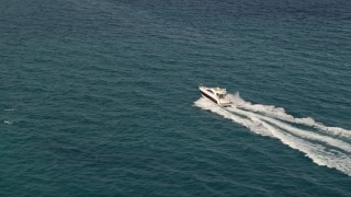 AX0021_043E - 5K stock footage aerial video approach fishing boats racing across the blue water of the ocean near South Beach, Florida