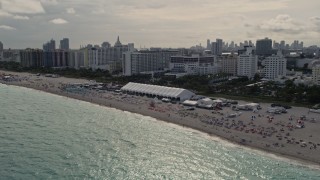 AX0021_052E - 5K stock footage aerial video of beachgoers and oceanfront hotels in Miami Beach, Florida