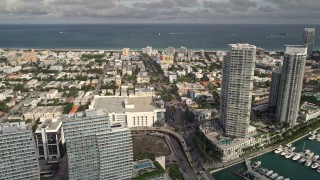 AX0021_063E - 5K aerial stock footage of slow traffic on the MacArthur Causeway, tilt to condos and marina, South Beach, Florida