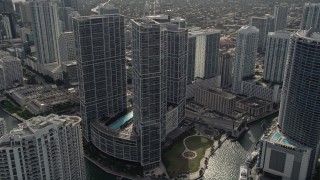 AX0021_080E - 5K aerial stock footage fly over Miami River to approach high-rise complex in Downtown Miami, Florida