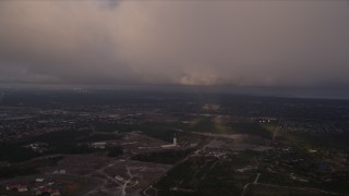 AX0022_020E - 5K aerial stock footage fly under the edge of a cloud formation at sunset near Zoo Miami, Florida